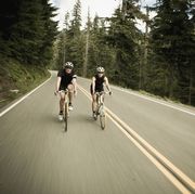 man and woman bicycling though the forest
